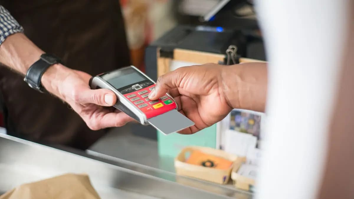 Comerciant care calculează costul lunar al unui program de fidelizare la tejgheaua magazinului